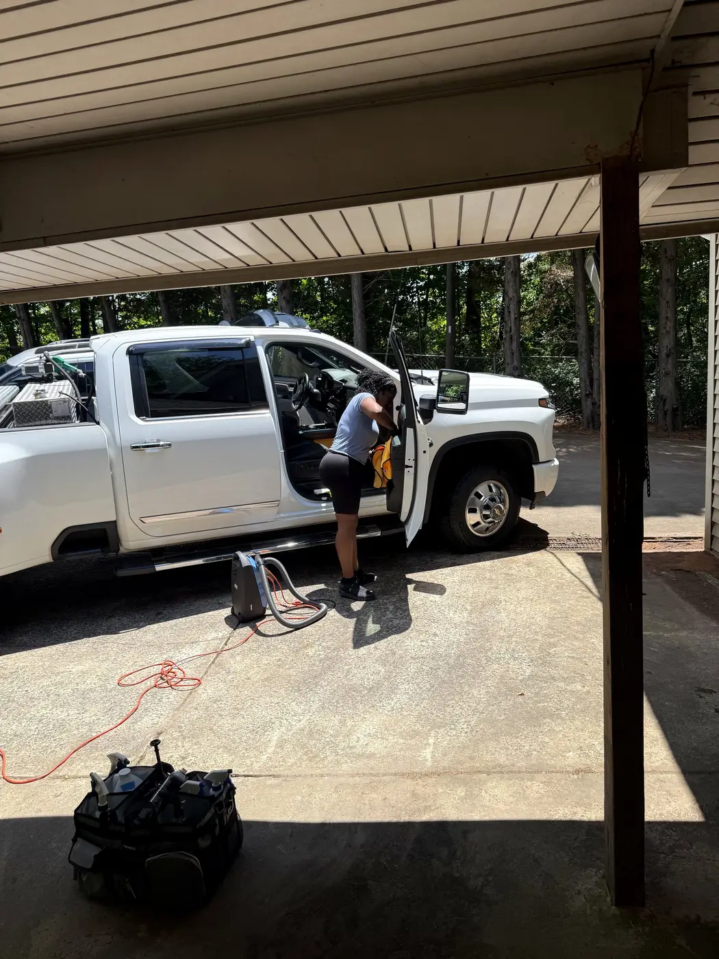 Signature technician detailing a white pickup truck at a customer location