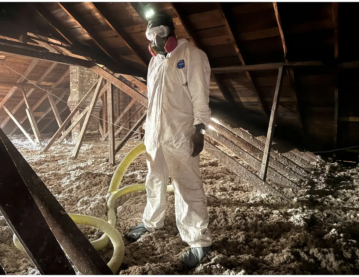 Signature Home Services technician in protective equipment during an attic insulation top-off